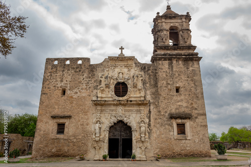 Historical Mission San José old spanish architecture building and green lush plants. Photo taken in San Antonio Texas on a cloudy day photo