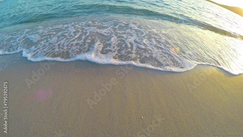 Small waves in a sandy foreshore at sunset photo
