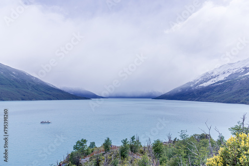 A boat is floating on a lake with a cloudy sky in the background