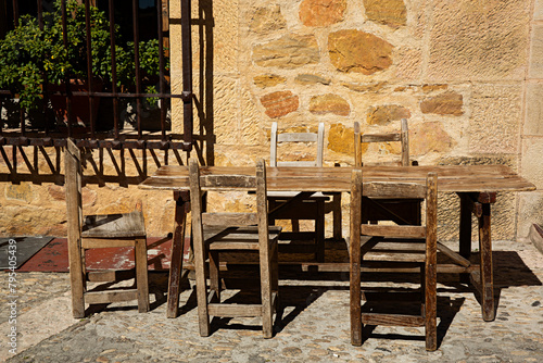 Mesa y silla de madera de un restaurante en la calle.