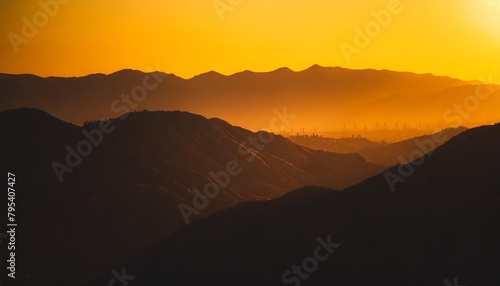 orange and yellow sunset above layers of mountains