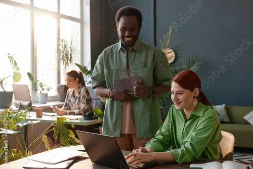 Portrait of smiling young people working together in modern office with sunlight contour copy space 