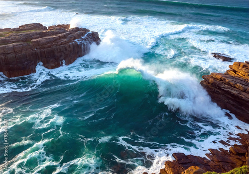 Beautiful aerial view early morning light with ocean waves flowing over rocks around the ocean rock pool during storm.