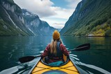 Fjord Serenity: Girl's Canoe Journey Offers Stunning Views of Majestic Waterways from Behind