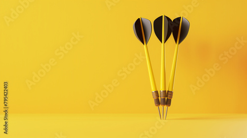 Three black-yellow darts against plain yellow background with copy space. Concept of sports or business goal and target. photo