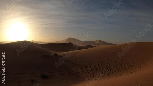 Wind in the sand dunes of Erg Chebbi at sunrise, Sahara desert, Morocco photo