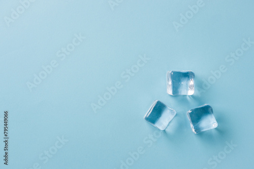 top view of ice cubes of different sizes on blue background © yalcinsonat