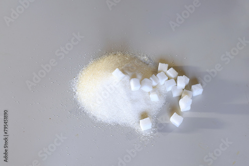 Slices of refined sugar and granulated sugar sand on the table. photo