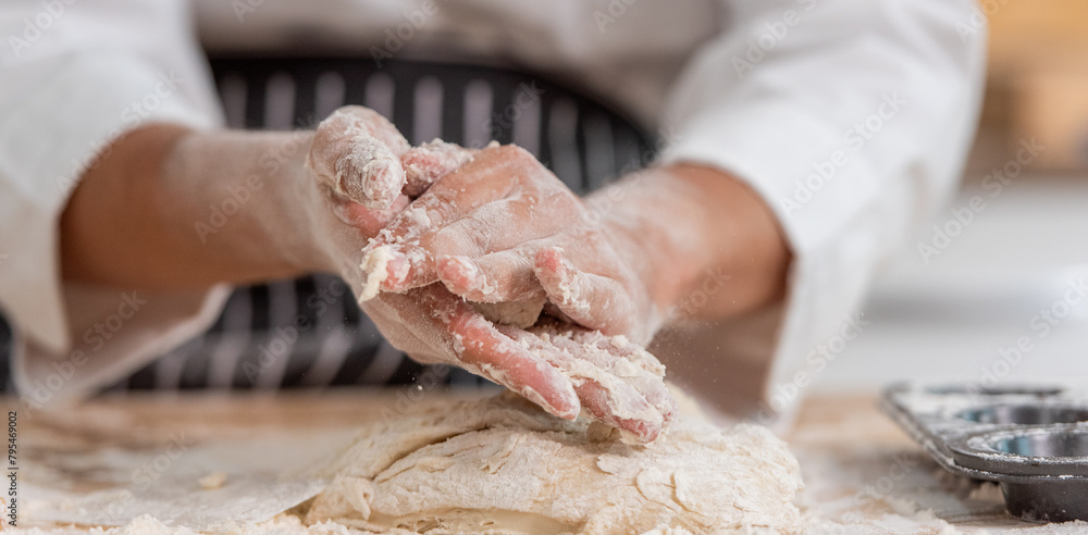 professional Chef sifting flour powder and sprinkling ingredients on massaging dough for bakery cooking. Chef show dirty finger hand sifting flour wheat and kneading dough mixing powder.