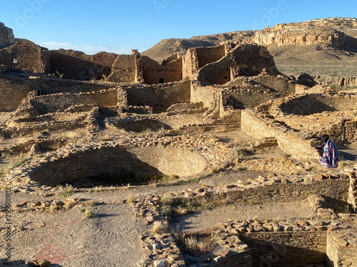 Chaco Culture National Historical Park in New Mexico. Pueblo del Arroyo great house and woman in blanket. Chaco Canyon was a major Ancestral Puebloan culture center and has many pueblos.  photo