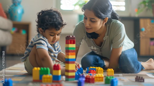 Loving young Indian mother and little son playing together on heating floor, building towers from toy construction bricks, talking, enjoying leisure, playtime, creative game. Motherhood concept photo