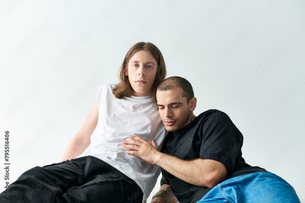 Two men, in loving embrace, sit on a bean bag chair in a cozy setting. Two men, in loving embrace, sit on a bean bag chair in a cozy setting.