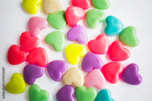 Multi-colored plastic hearts on a white background. Background for Valentine's day