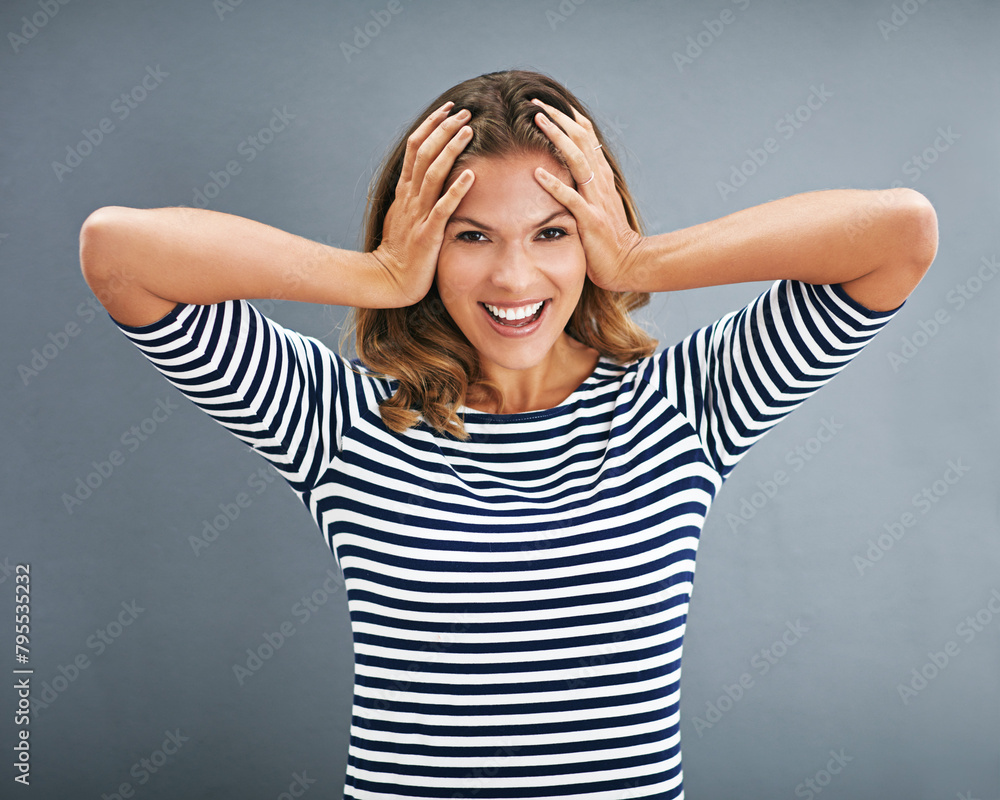Model, portrait and covered ears with studio, excitement and celebration for winner. Woman, smile and happiness for good news, promotion and achievement with victory isolated on grey background Model, portrait and covered ears with studio, excitement and celebration for winner. Woman, smile and happiness for good news, promotion and achievement with victory isolated on grey background