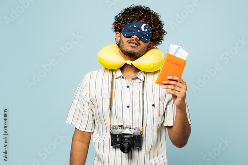 Traveler Indian man wear white casual clothes mask hold passport sleep ticket isolated on plain blue background. Tourist travel abroad in free spare time rest getaway. Air flight trip journey concept. #795540805