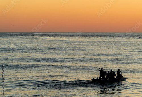 Фотография Group of refugees on a boat, fleeing from war and hunger and asking for humanita