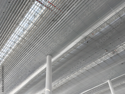 Lights and ventilation system in long line on ceiling of the industrial building. Exhibition Hall. Ceiling factory construction. © Aleksei
