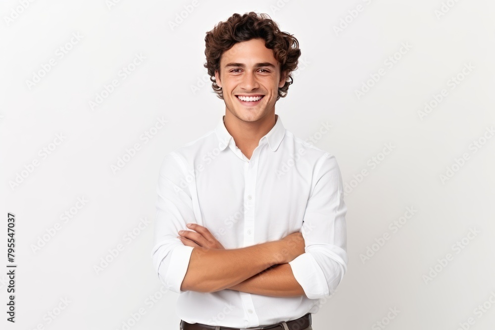 A man with a white shirt and brown pants is smiling and crossing his arms. Concept of confidence and self assurance A man with a white shirt and brown pants is smiling and crossing his arms. Concept of confidence and self assurance