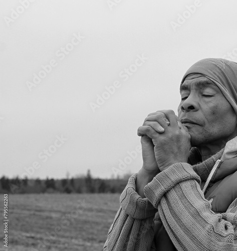 praying to god with hands together on dark background stock photo