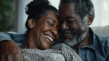 Close-up portrayal of a mature Black couple sharing genuine laughter at home, highlighting their successful and content life together