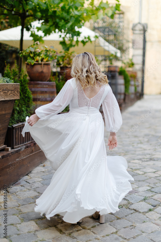 Woman in white dress walking down the street Woman in white dress walking down the street
