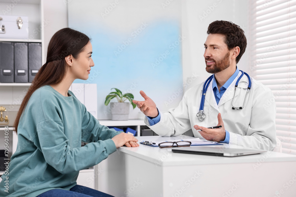 Doctor consulting patient during appointment in clinic Doctor consulting patient during appointment in clinic