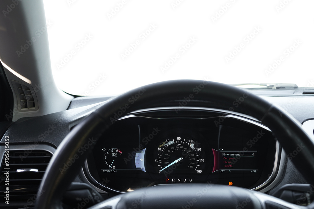 Speedometer on dashboard and steering wheel inside car