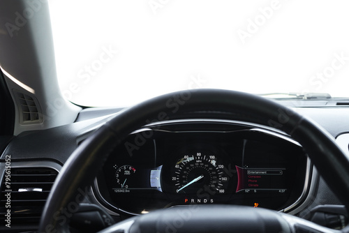 Speedometer on dashboard and steering wheel inside car © New Africa