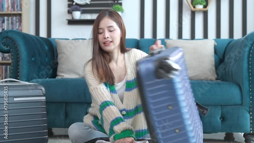 Holiday travel , traveler Asian young woman, check list note and preparing stuff into luggage for journey trip, preparation for journey voyage at home. Vacation traveling concept.