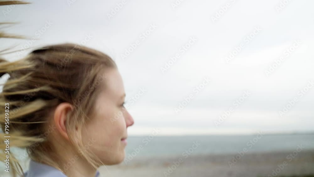 Blurred motion portrait of smiling woman by the sea