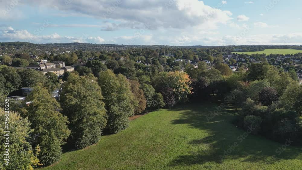 A high angle drone view over green parks and suburbs of London.