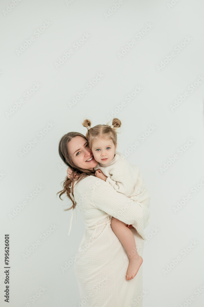 Beautiful young pregnant woman with her little 3 yearold daughter on white background. Stylish pregnant woman in beige dress. Motherhood. Mother's Day. Beautiful young pregnant woman with her little 3 yearold daughter on white background. Stylish pregnant woman in beige dress. Motherhood. Mother's Day.
