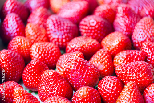 dense group of succulent strawberries create a colorful red texture