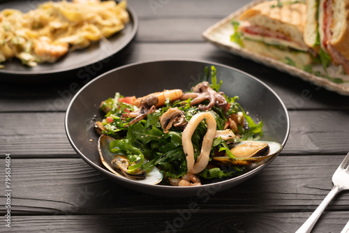 Seafood salad, mix of squid, shrimp and mussels mixed with arugula and sesame seeds