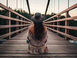 Chica bohemia sentada en un puente