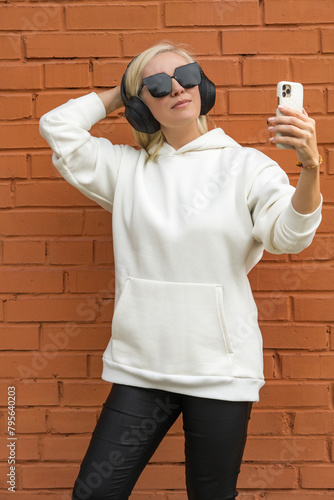 Stylish blonde woman taking a selfie with headphones photo