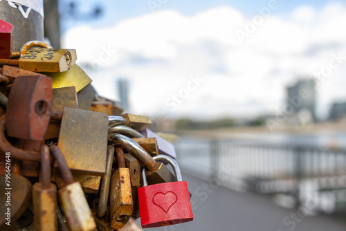 Many love locks on a publice bridge with the sky in the background
