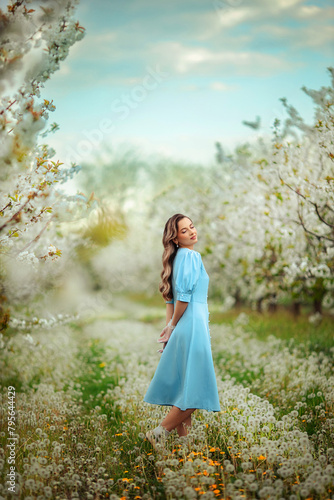 portrait of a beautiful young woman in aesthetic clothes on a walk in a blooming spring garden