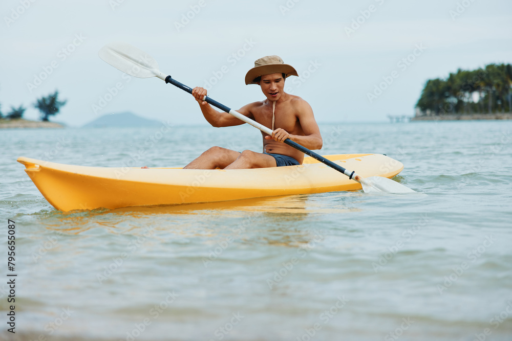 Happy Asian Man Kayaking on Tropical Beach, Enjoying Summer Vacation Adventure