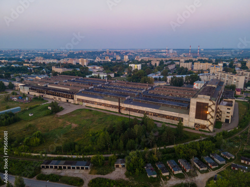 Drone view of production building in small city at sunset