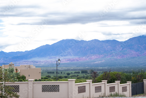 Beautiful estate in a large vineyard winery with colorful mountains and clouds in the background photo
