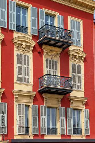 Architectural fragments of the facade of an ancient red house in Limpia Port. Nice, capital of the Alpes-Maritimes department on the French Riviera.