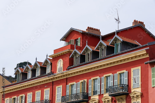 Architectural fragments of the facade of an ancient red house in Limpia Port. Nice, capital of the Alpes-Maritimes department on the French Riviera.