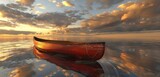 Wooden canoe on calm water during sunset, reflecting golden light.