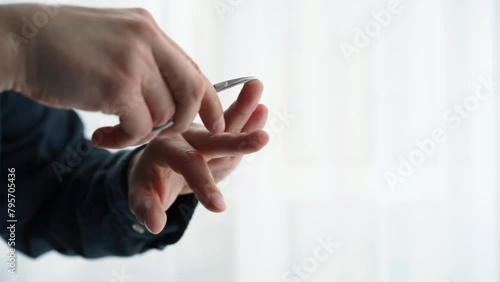 A man cuts his own nails.
Man giving himself a manicure photo