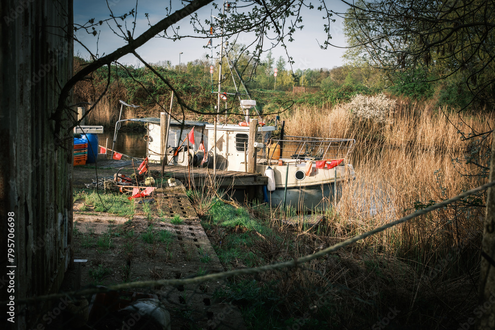 a small fishing boat lies on the shore of a lake a small fishing boat lies on the shore of a lake
