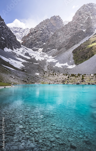 Mountain panorama  landscape with rocky peaks and blue turquoise lake Ziyorat in the Fan Mountains in Tajikistan  on a sunny summer day