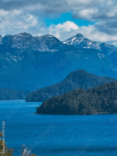 A beautiful mountain range with a lake in the foreground. The mountains are covered in snow and the lake is calm and blue. The scene is serene and peaceful  with the mountains