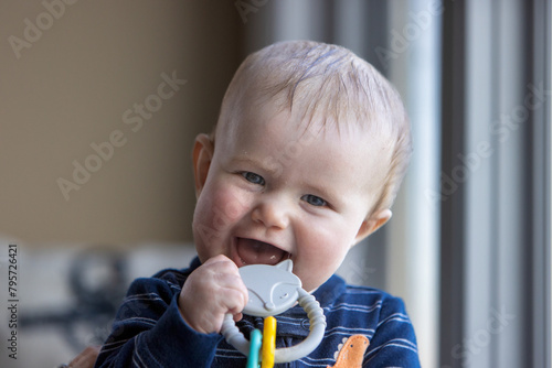 Smiling six month old child holding a toy.