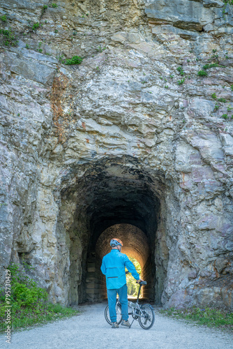 Male cyclist with a folding bike on Katy Trail at a tunnel near Rocheport, Missouri, spring scenery. The Katy Trail is 237 mile bike trail converted from an old railroad. photo